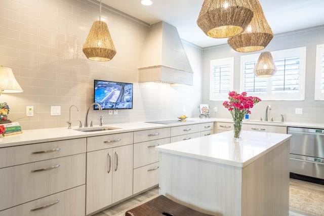 kitchen featuring a sink, light countertops, custom exhaust hood, a center island, and decorative light fixtures