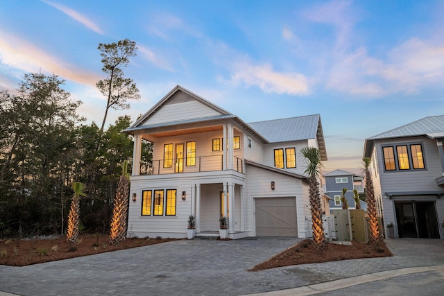 view of front of property featuring a garage and a balcony