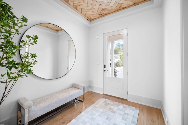 entryway with a raised ceiling and light wood-type flooring