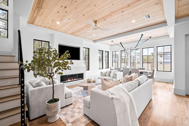 living room with a healthy amount of sunlight, wood ceiling, and light hardwood / wood-style flooring