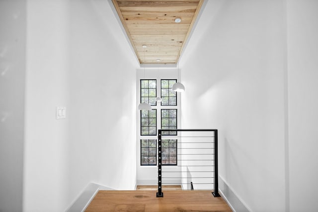 stairs with wood ceiling and hardwood / wood-style floors