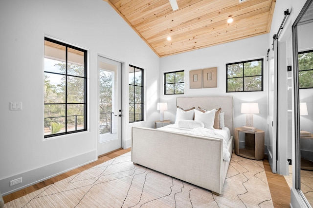 bedroom with a barn door, high vaulted ceiling, wooden ceiling, and light wood-type flooring