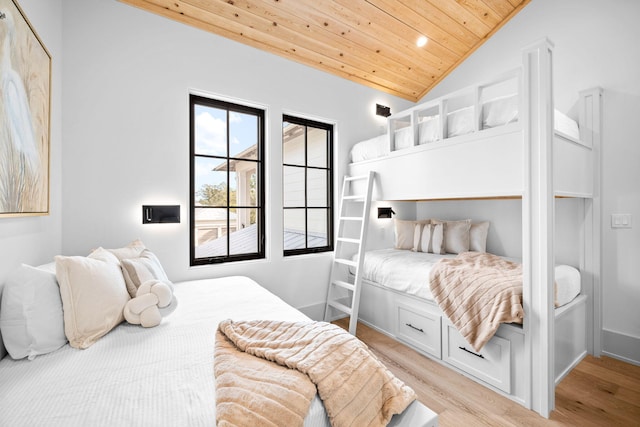 bedroom featuring vaulted ceiling, wood ceiling, and light hardwood / wood-style floors