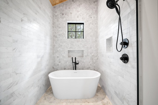 bathroom with a washtub and tile walls