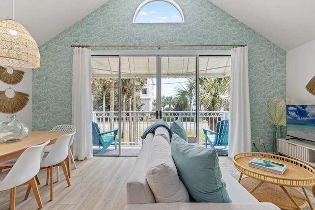 living room with vaulted ceiling, light wood-style flooring, and wallpapered walls