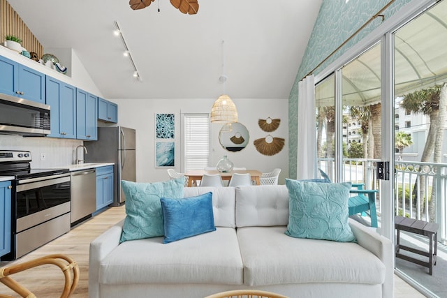 kitchen featuring stainless steel appliances, light countertops, blue cabinets, and decorative light fixtures