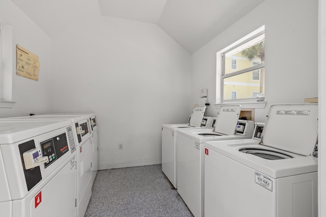 community laundry room featuring washing machine and dryer and baseboards