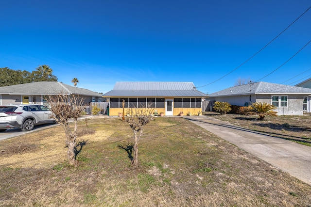 ranch-style house with a front lawn and a sunroom