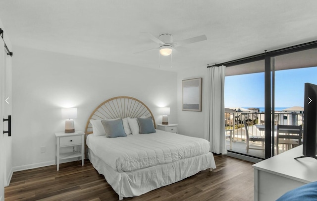 bedroom with expansive windows, a barn door, dark hardwood / wood-style flooring, and access to outside