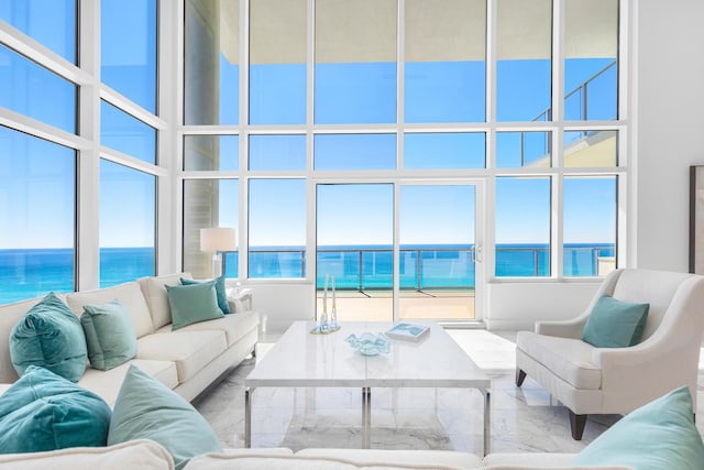 living room featuring a water view and a towering ceiling