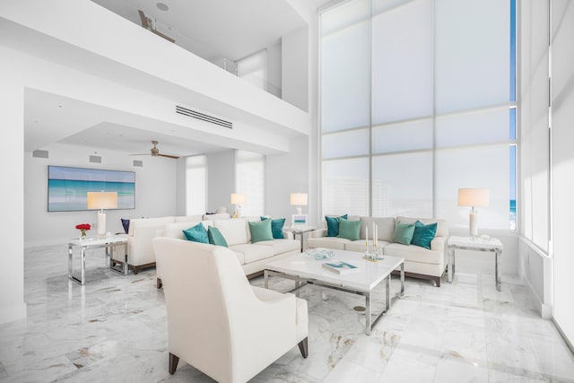 living room with ceiling fan, marble finish floor, a towering ceiling, and visible vents