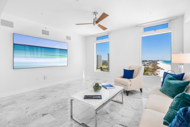 living area with visible vents, marble finish floor, ceiling fan, and a wealth of natural light