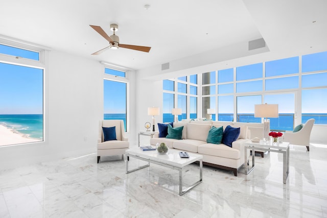 living room with marble finish floor, a water view, visible vents, and a ceiling fan