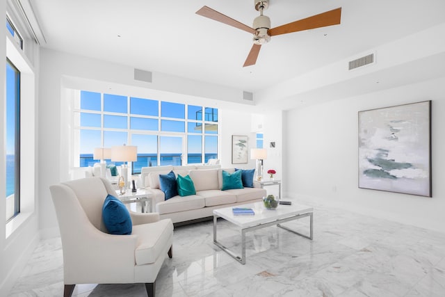 living room featuring ceiling fan, marble finish floor, and visible vents