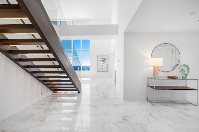 staircase with marble finish floor and baseboards