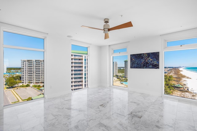 unfurnished room featuring ceiling fan and marble finish floor