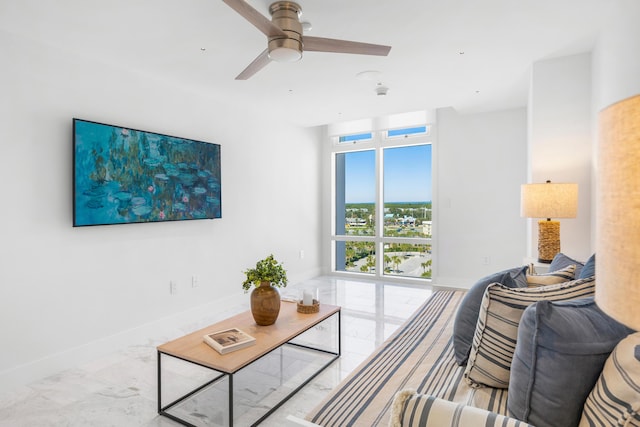 living area featuring marble finish floor, baseboards, and a ceiling fan