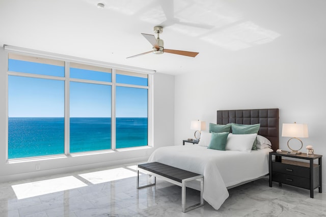 bedroom with ceiling fan, marble finish floor, and a water view