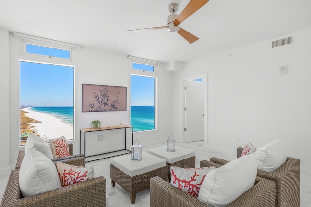 living room featuring a healthy amount of sunlight, visible vents, a water view, and ceiling fan