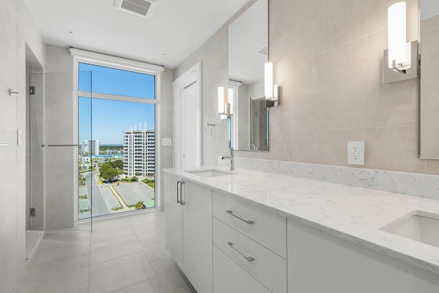 full bathroom with a healthy amount of sunlight, a stall shower, visible vents, and a sink