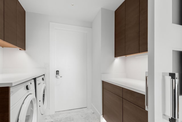 clothes washing area featuring marble finish floor, cabinet space, and washing machine and clothes dryer