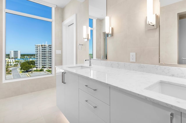 full bathroom with a view of city, tile patterned flooring, a sink, and double vanity