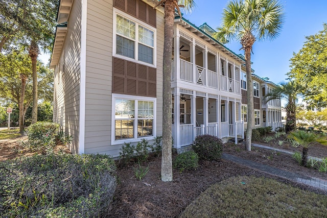 exterior space featuring a balcony, covered porch, and a ceiling fan