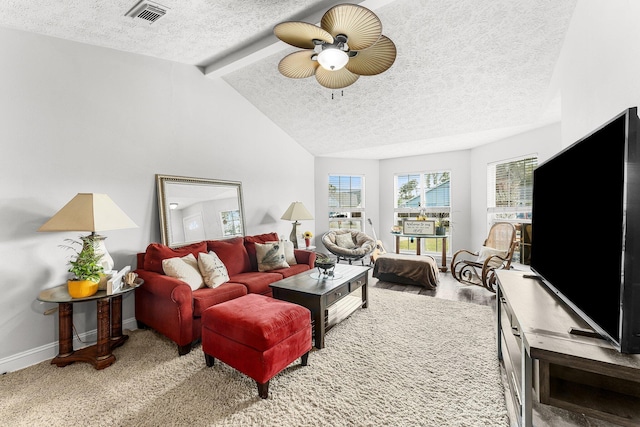 living room featuring ceiling fan, lofted ceiling with beams, a textured ceiling, and carpet