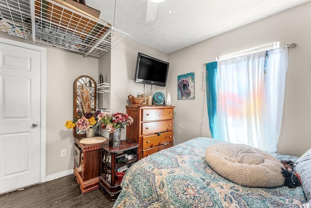 bedroom with ceiling fan, dark wood-type flooring, and a textured ceiling