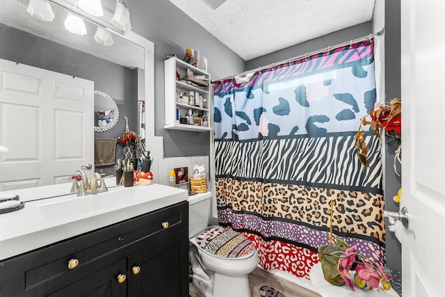 bathroom with walk in shower, toilet, a textured ceiling, vanity, and hardwood / wood-style floors