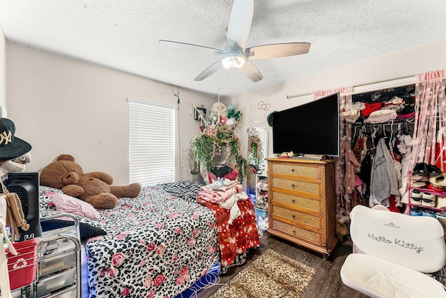 bedroom featuring ceiling fan, a textured ceiling, dark hardwood / wood-style flooring, and a closet