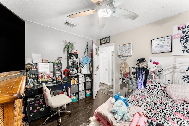 bedroom featuring ceiling fan, dark hardwood / wood-style floors, and a textured ceiling