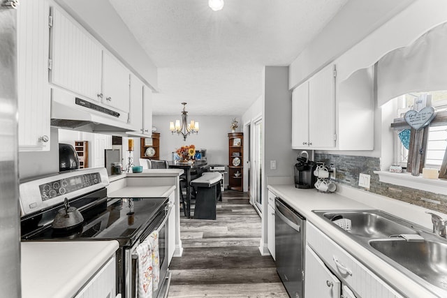 kitchen featuring sink, appliances with stainless steel finishes, white cabinetry, decorative light fixtures, and a chandelier