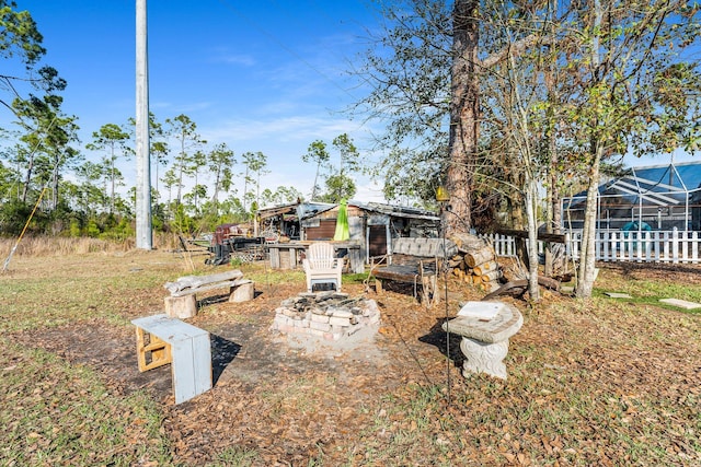 view of yard with an outdoor fire pit and a lanai