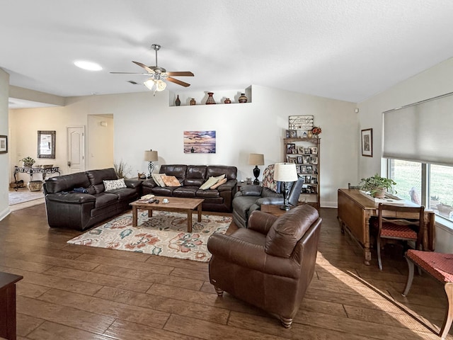 living room featuring dark wood-type flooring, ceiling fan, and vaulted ceiling