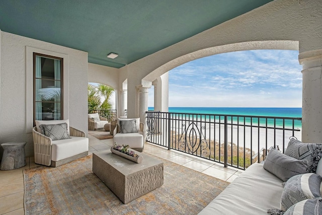 balcony featuring an outdoor hangout area, a view of the beach, and a water view