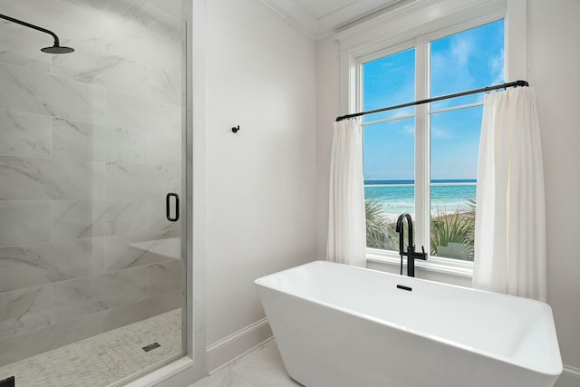 bathroom with marble finish floor, ornamental molding, a shower stall, baseboards, and a soaking tub