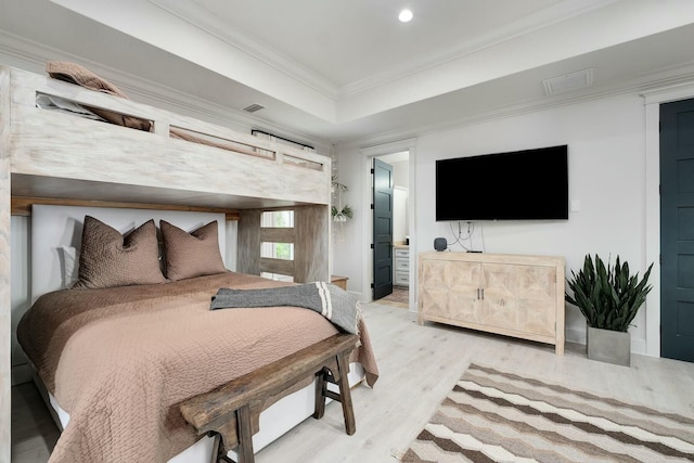 bedroom featuring light wood finished floors, visible vents, and crown molding