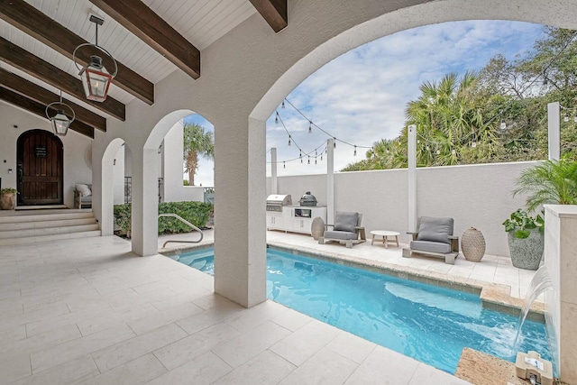 view of swimming pool featuring a fenced in pool, a patio, area for grilling, and exterior kitchen