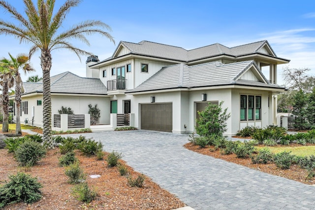 view of front of home with a tiled roof, decorative driveway, and a balcony