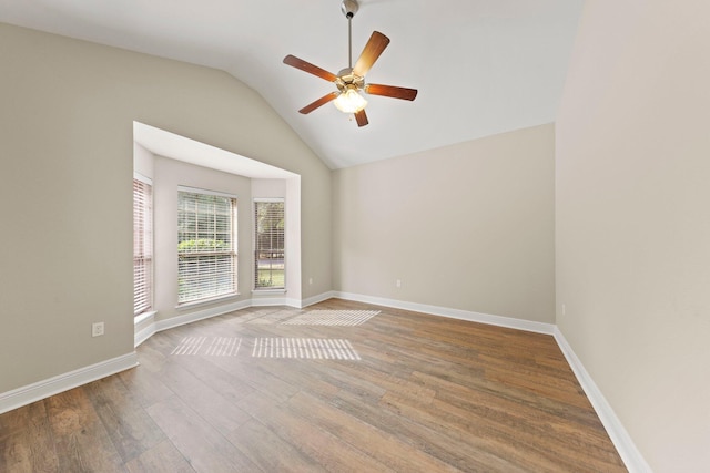 spare room featuring ceiling fan, wood-type flooring, and vaulted ceiling