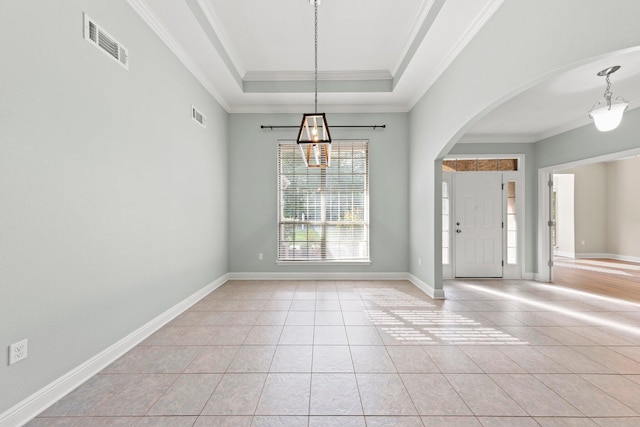 interior space featuring a raised ceiling, ornamental molding, and light tile patterned floors