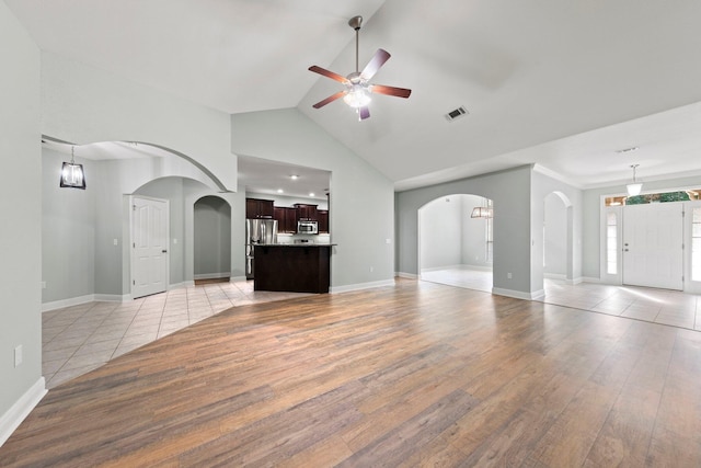 unfurnished living room featuring light hardwood / wood-style flooring, high vaulted ceiling, and ceiling fan