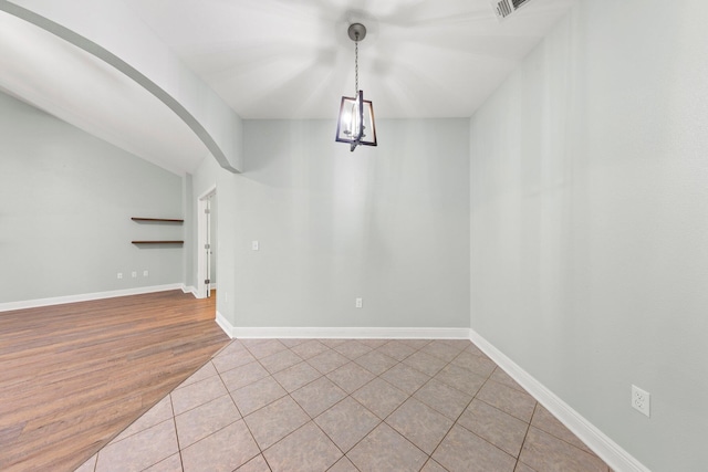 unfurnished dining area with lofted ceiling and light hardwood / wood-style floors