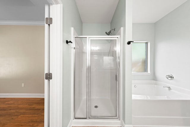 bathroom featuring plus walk in shower and hardwood / wood-style floors