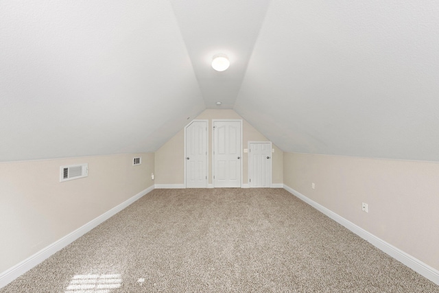 bonus room with lofted ceiling and carpet