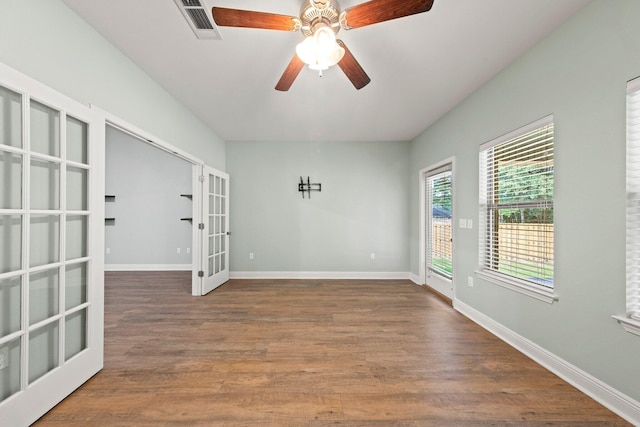 empty room featuring french doors, ceiling fan, and dark hardwood / wood-style flooring