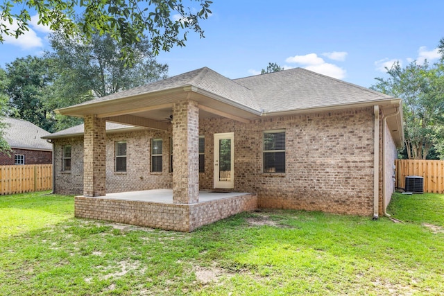 back of house with central AC, a patio, and a lawn