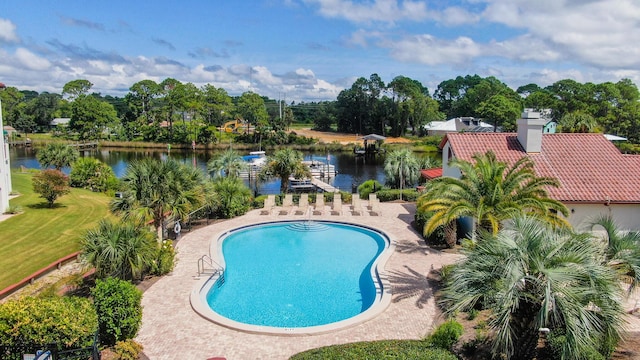 outdoor pool with a patio area and a water view