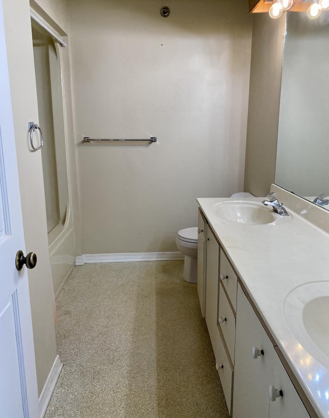 full bath featuring double vanity, baseboards, toilet, and a sink